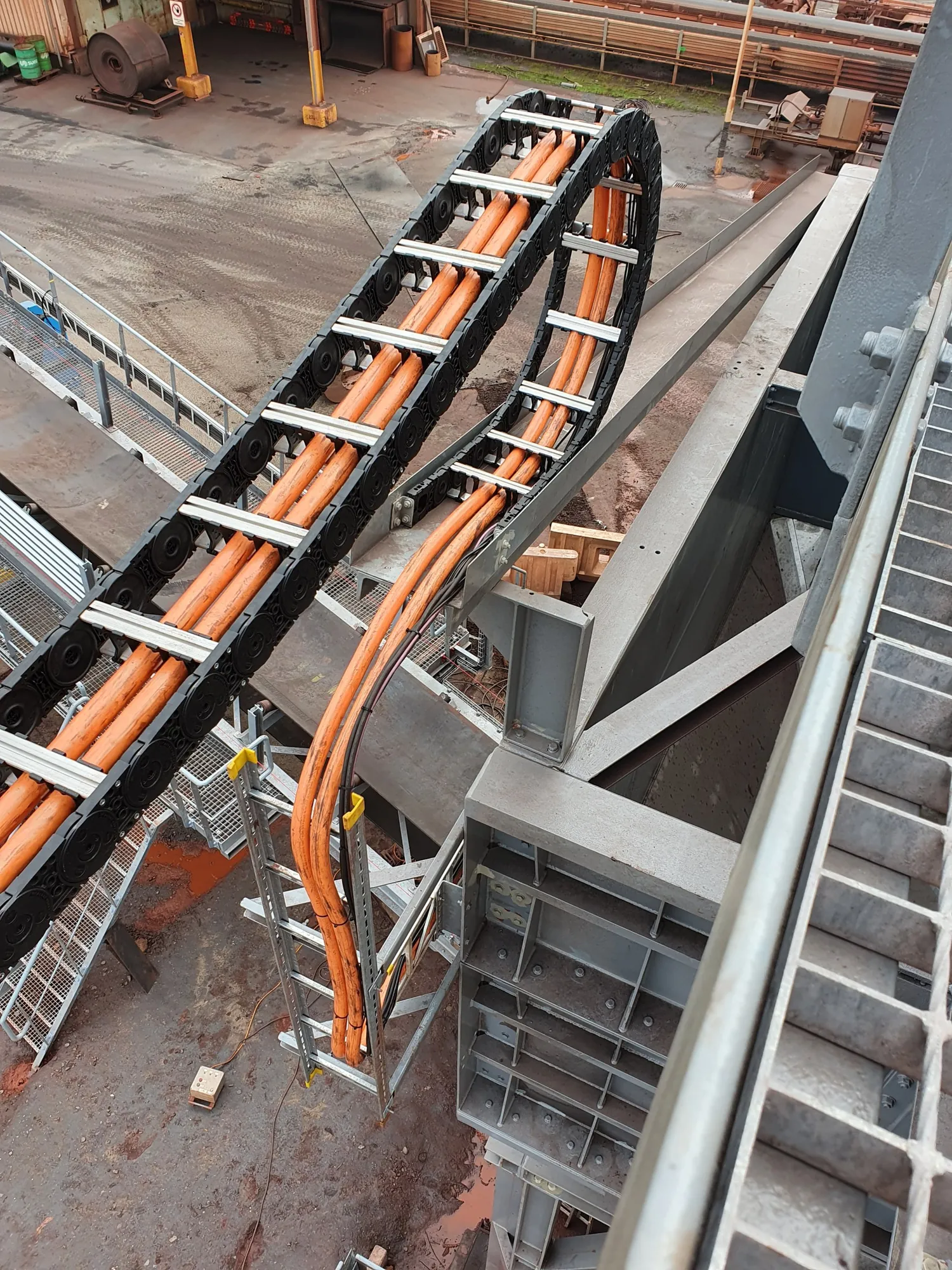 Die Energiekette mit den orangefarbenen Kabeln im Bogen