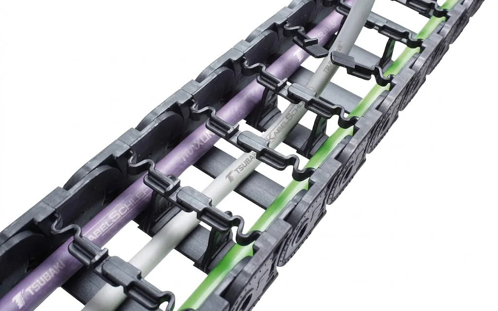 Grey cable carrier with purple, white and green cables, secured with black clamps